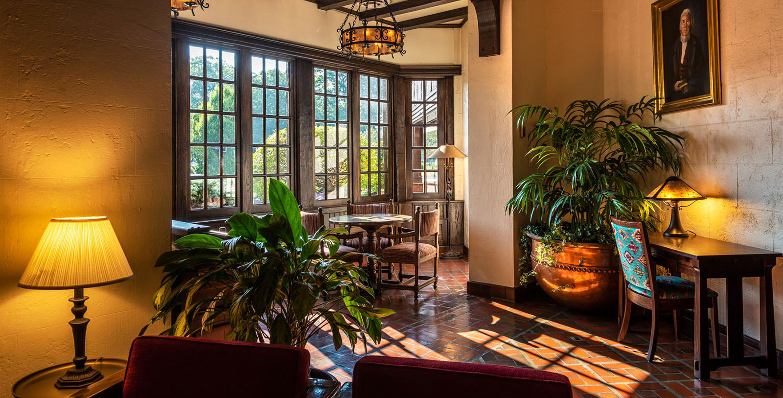 a room with a table and chairs and a potted plant