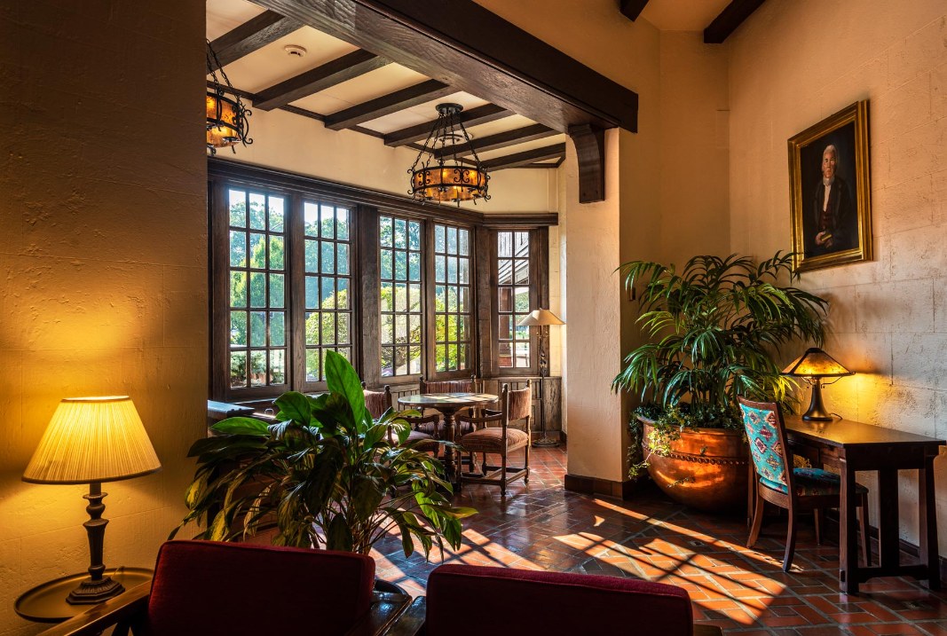 a room with a table and chairs and a plant