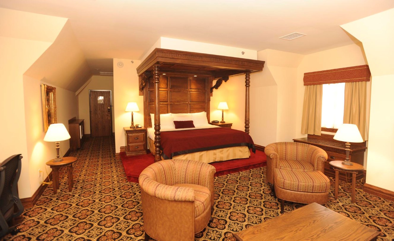 a room with a bed and chairs