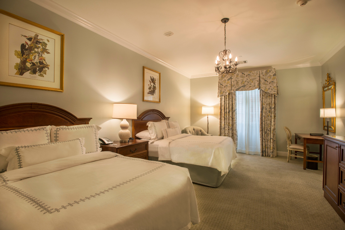 a room with two beds and a chandelier