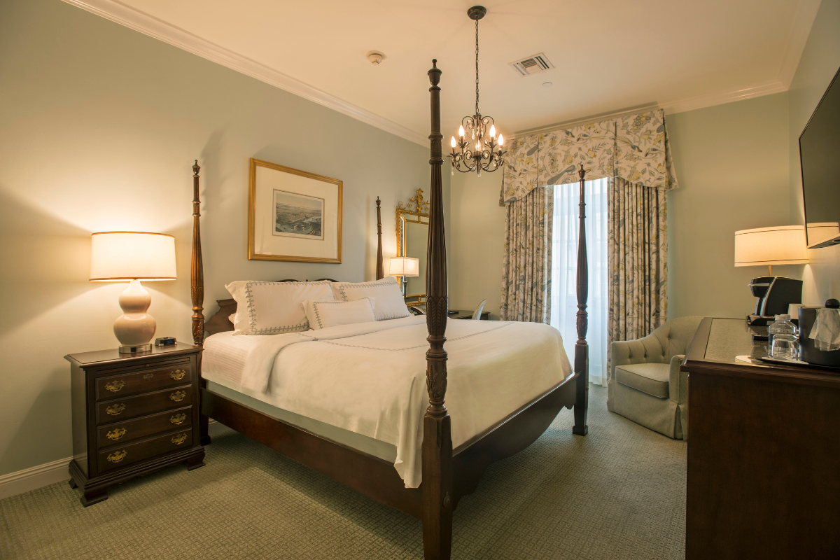 a bedroom with a four poster bed and a chandelier