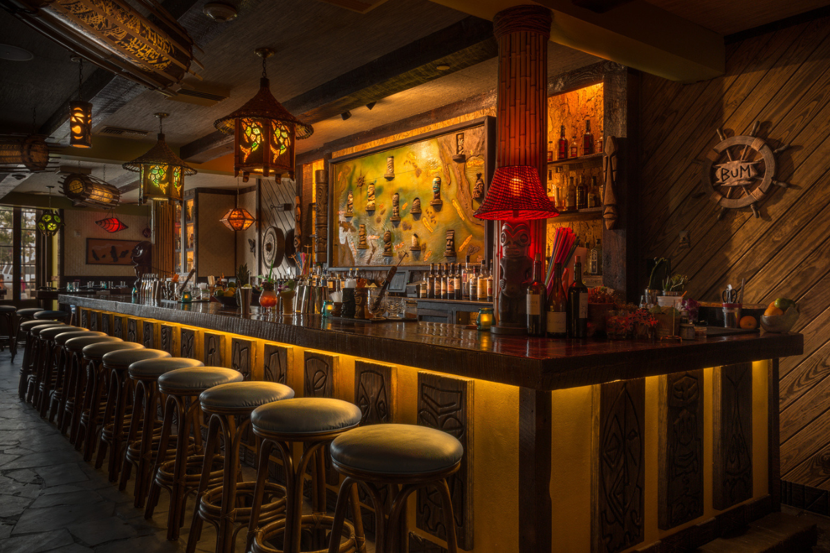 a bar with stools and bottles