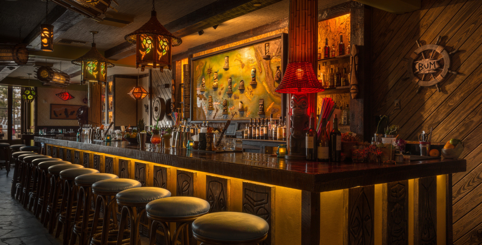 a bar with a red lamp and stools