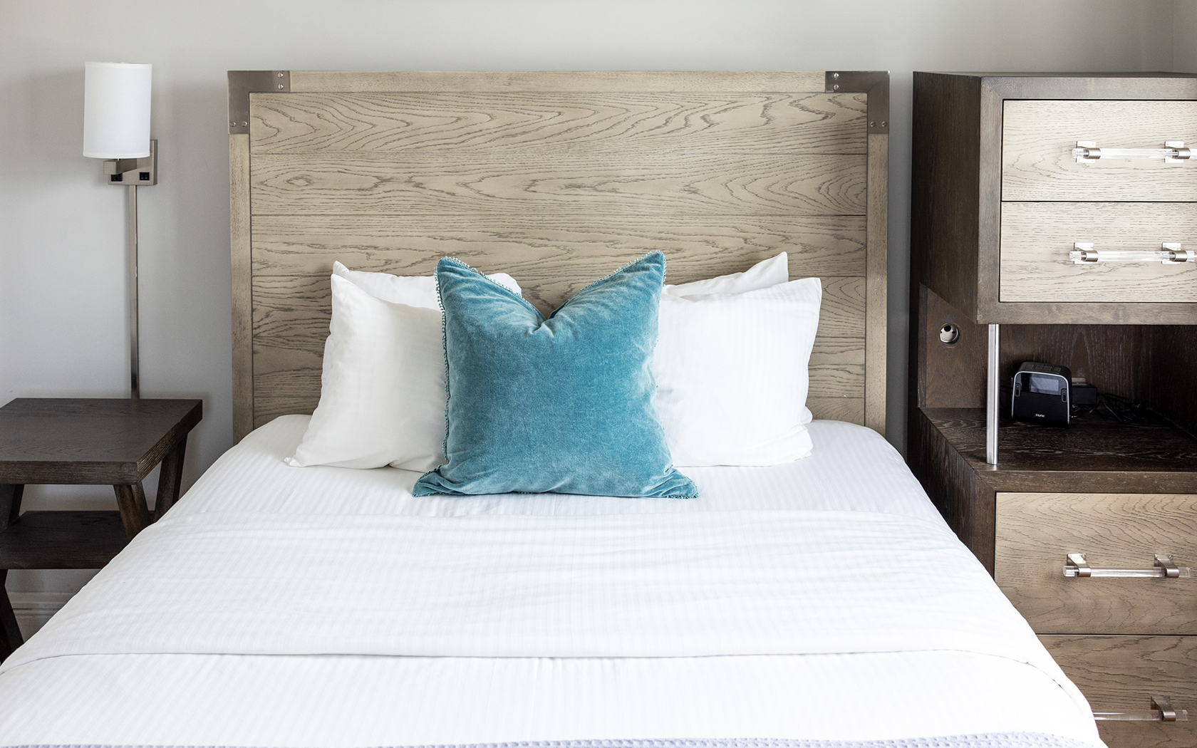 a bed with pillows and a wood headboard