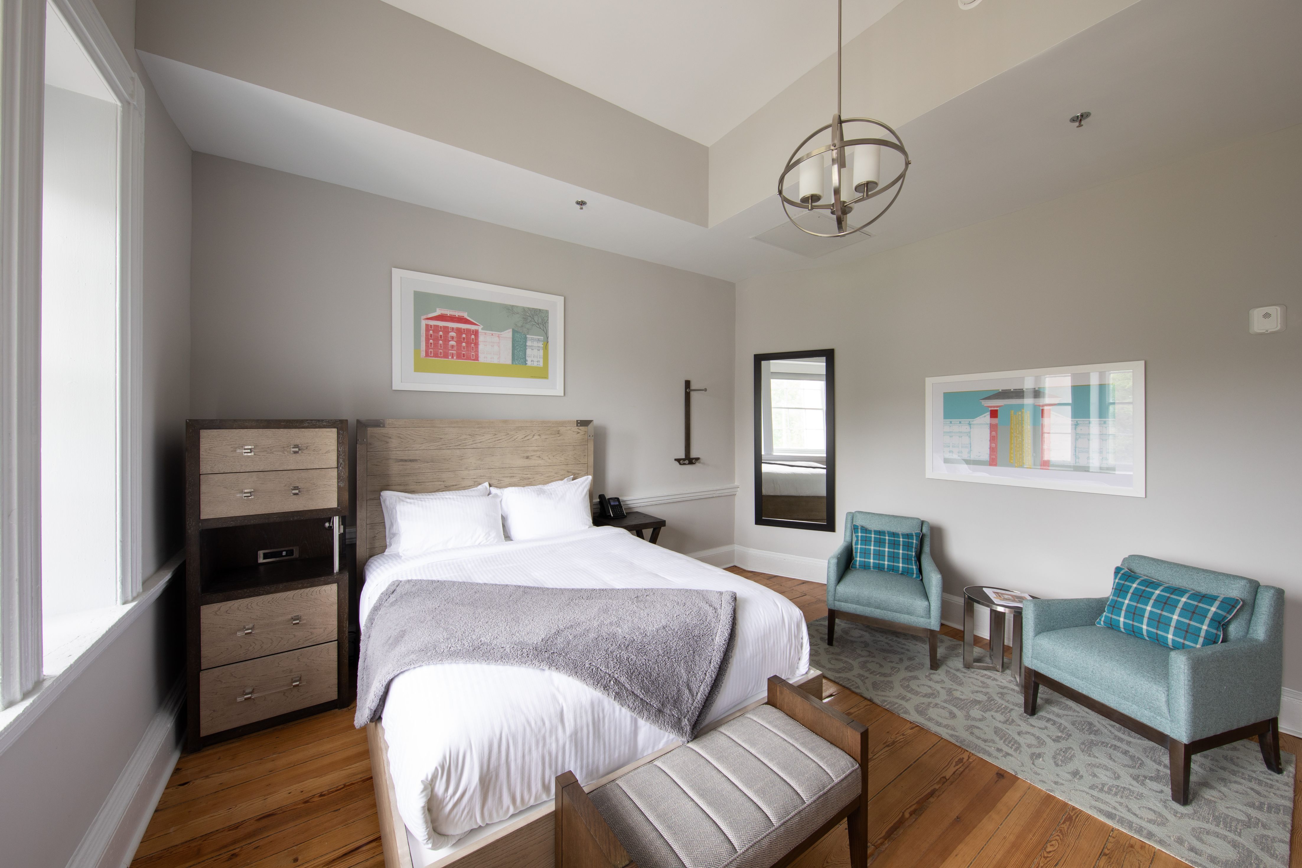 a bedroom with a bed and chairs