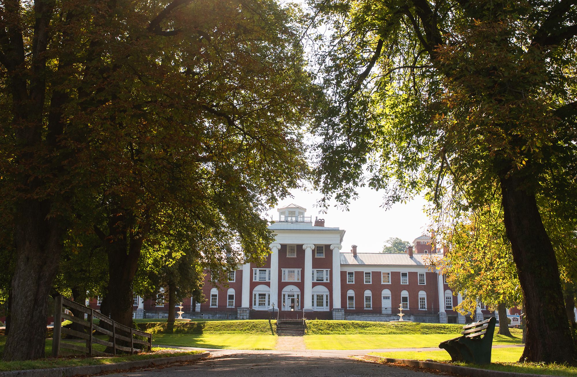 a large brick building with trees in the background