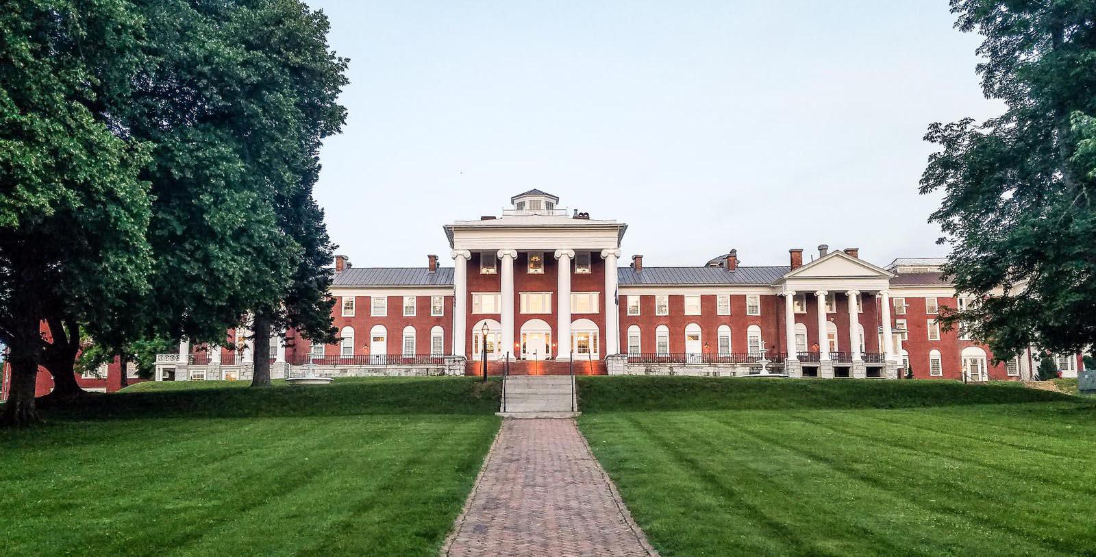 a large brick building with columns and a walkway leading to it