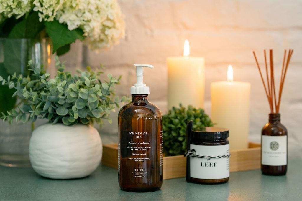 a bottle of liquid next to candles