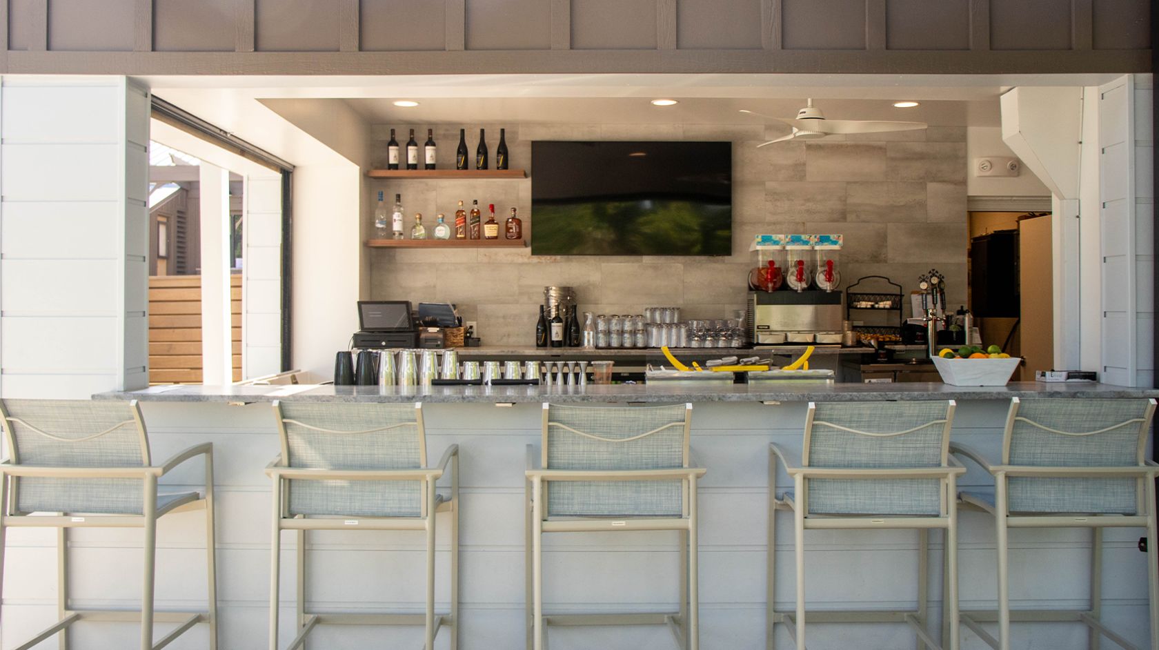 a bar with chairs and a television