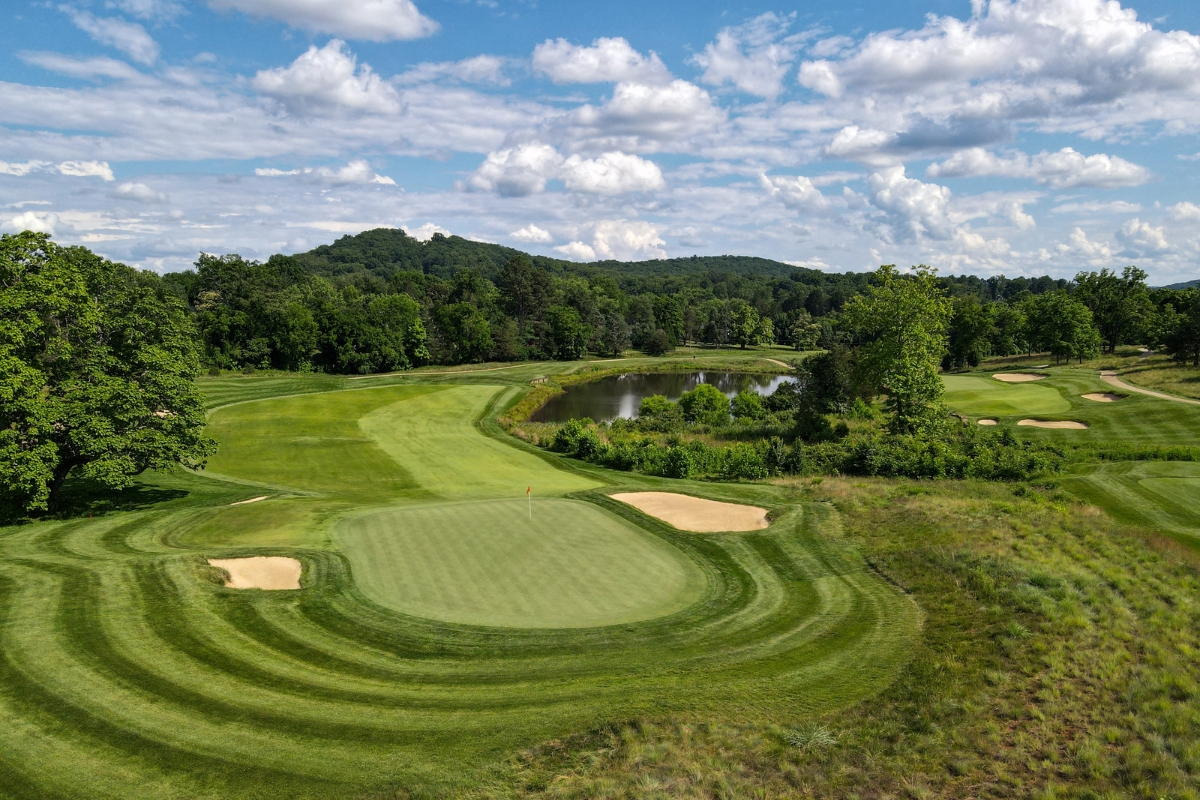 a golf course with a pond and trees