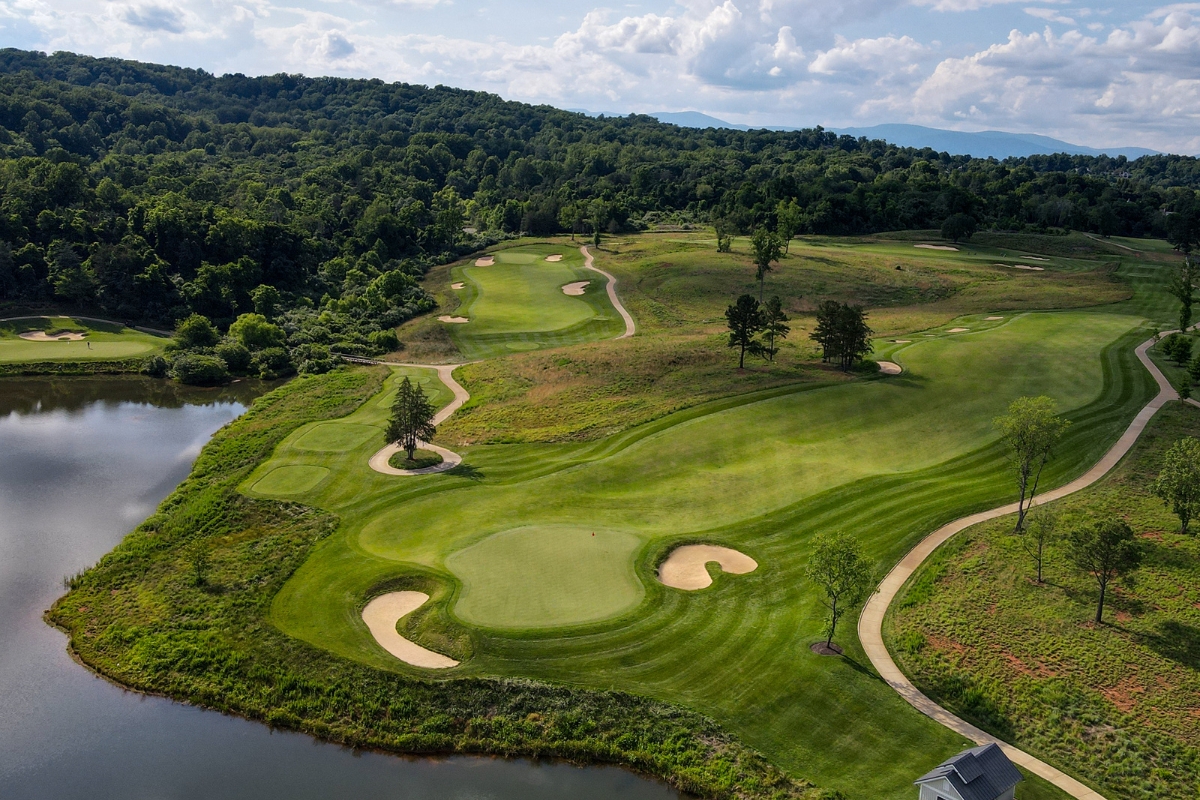 a golf course with a river and trees