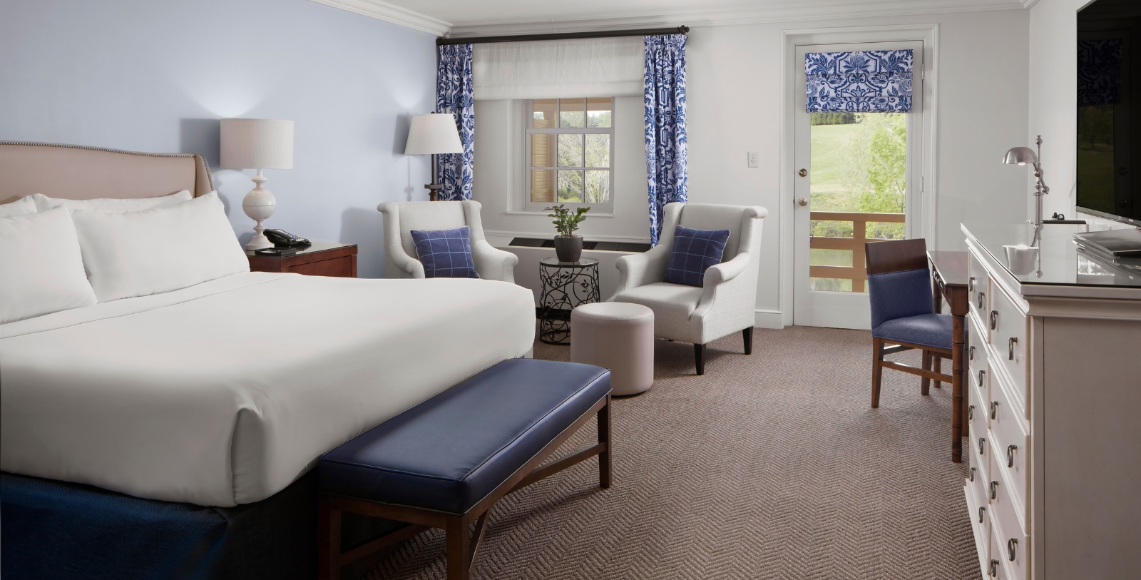 a room with a bed and chairs