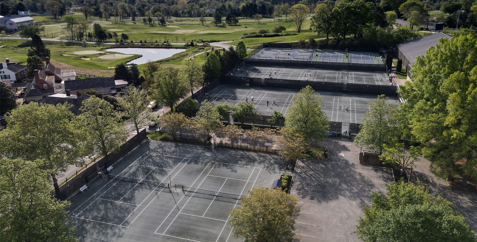 tennis courts with trees and grass