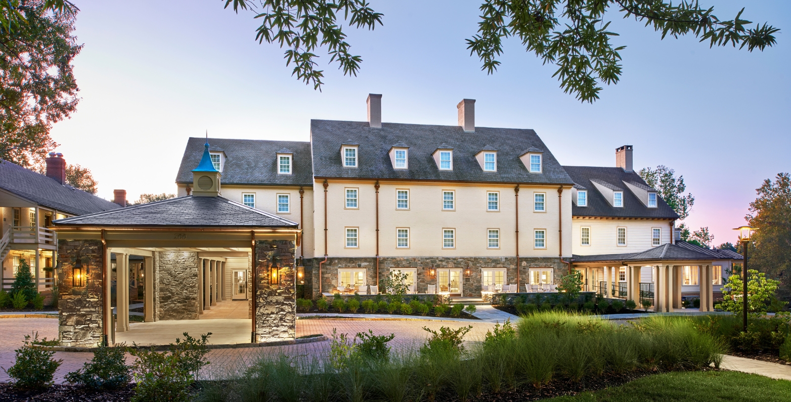 a large building with a stone walkway and a stone wall