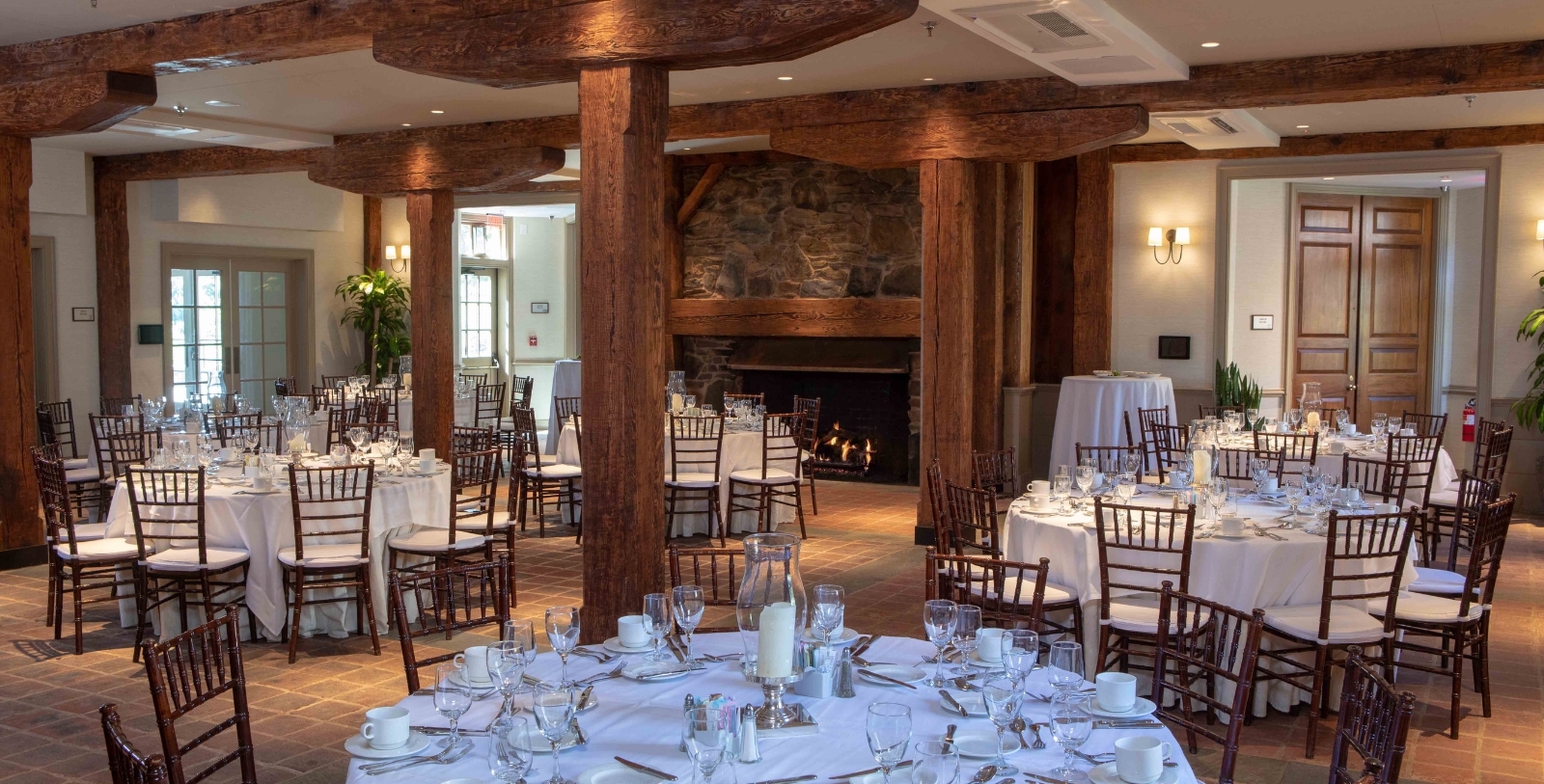 a room with tables and chairs and a fireplace