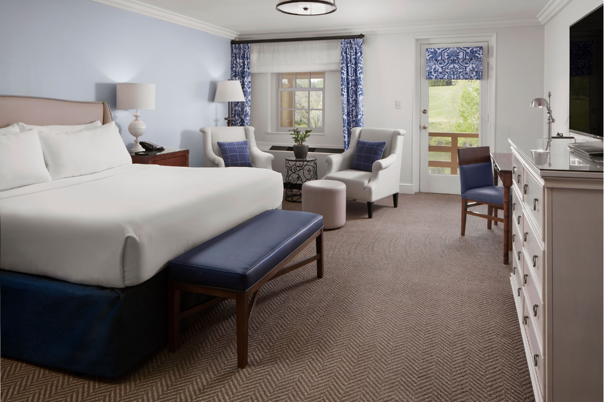 a room with a bed and chairs