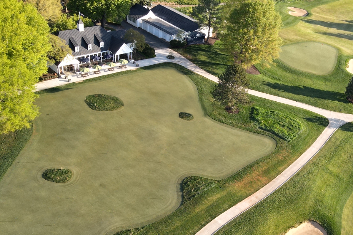 a golf course with a house and a golf course