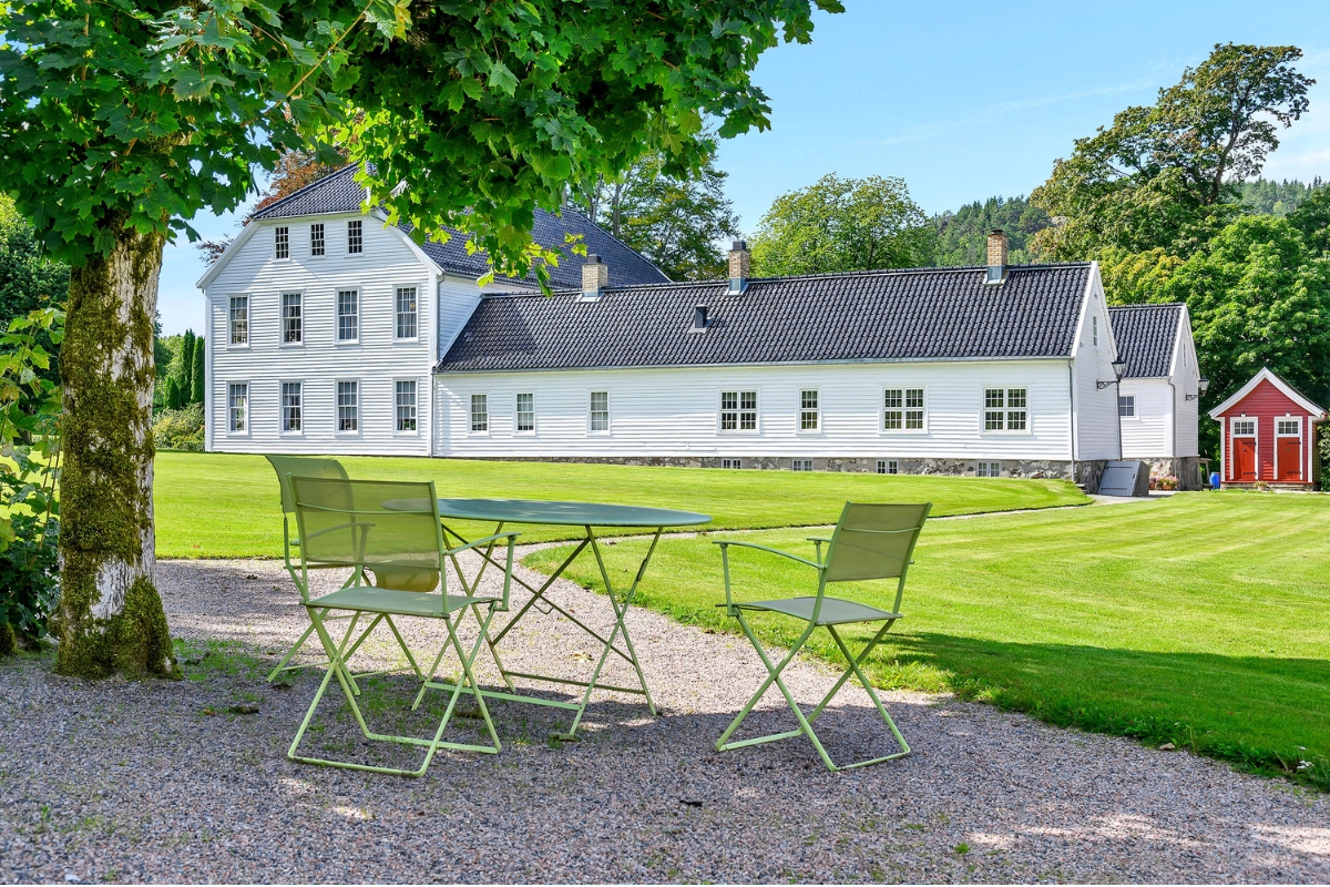 a table and chairs in front of a white house