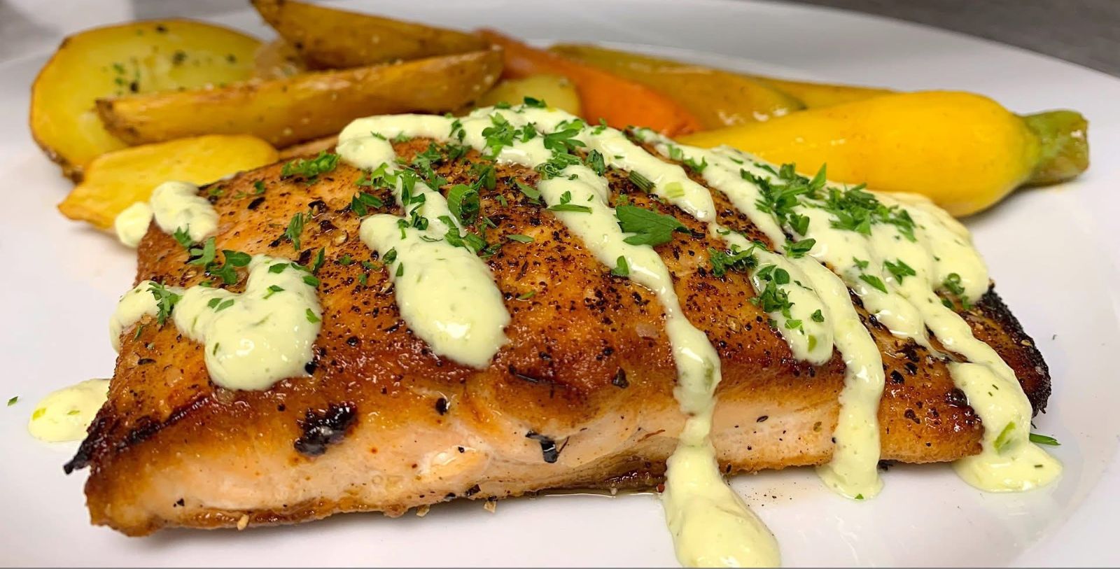 a plate of food with a white sauce on top
