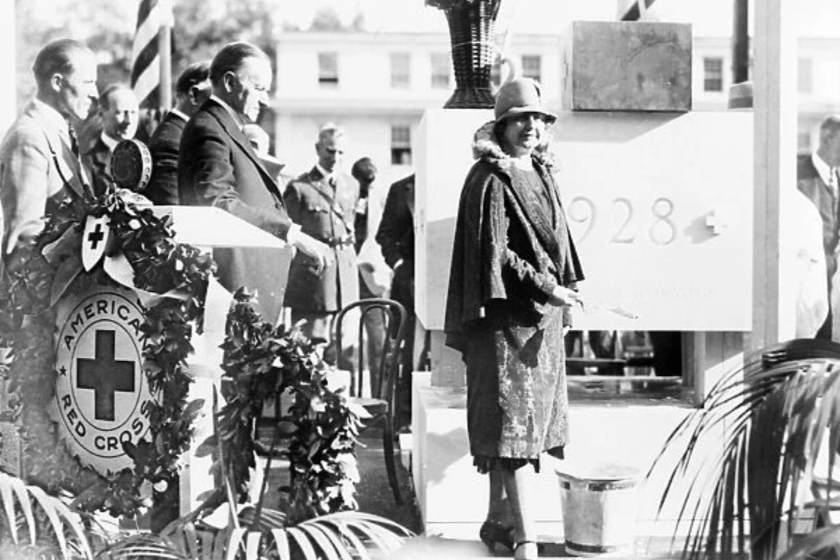 a woman standing in front of a white sign