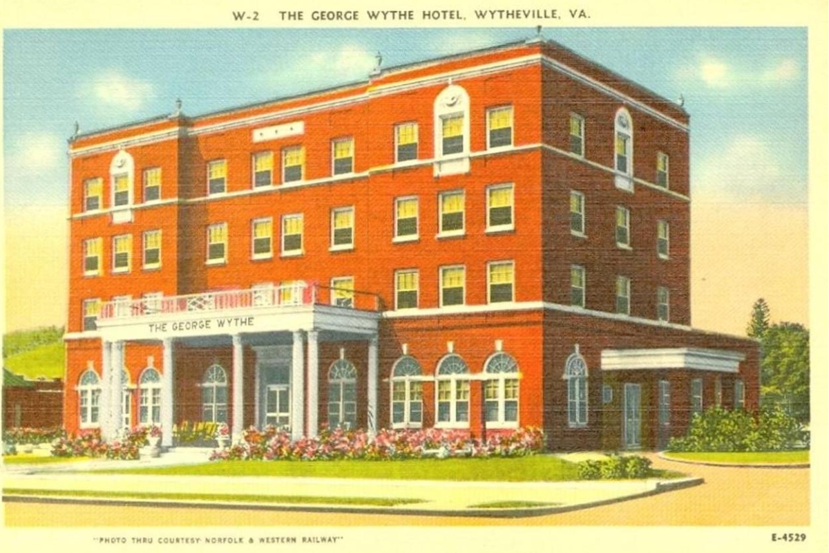 a large brick building with a lawn and flowers