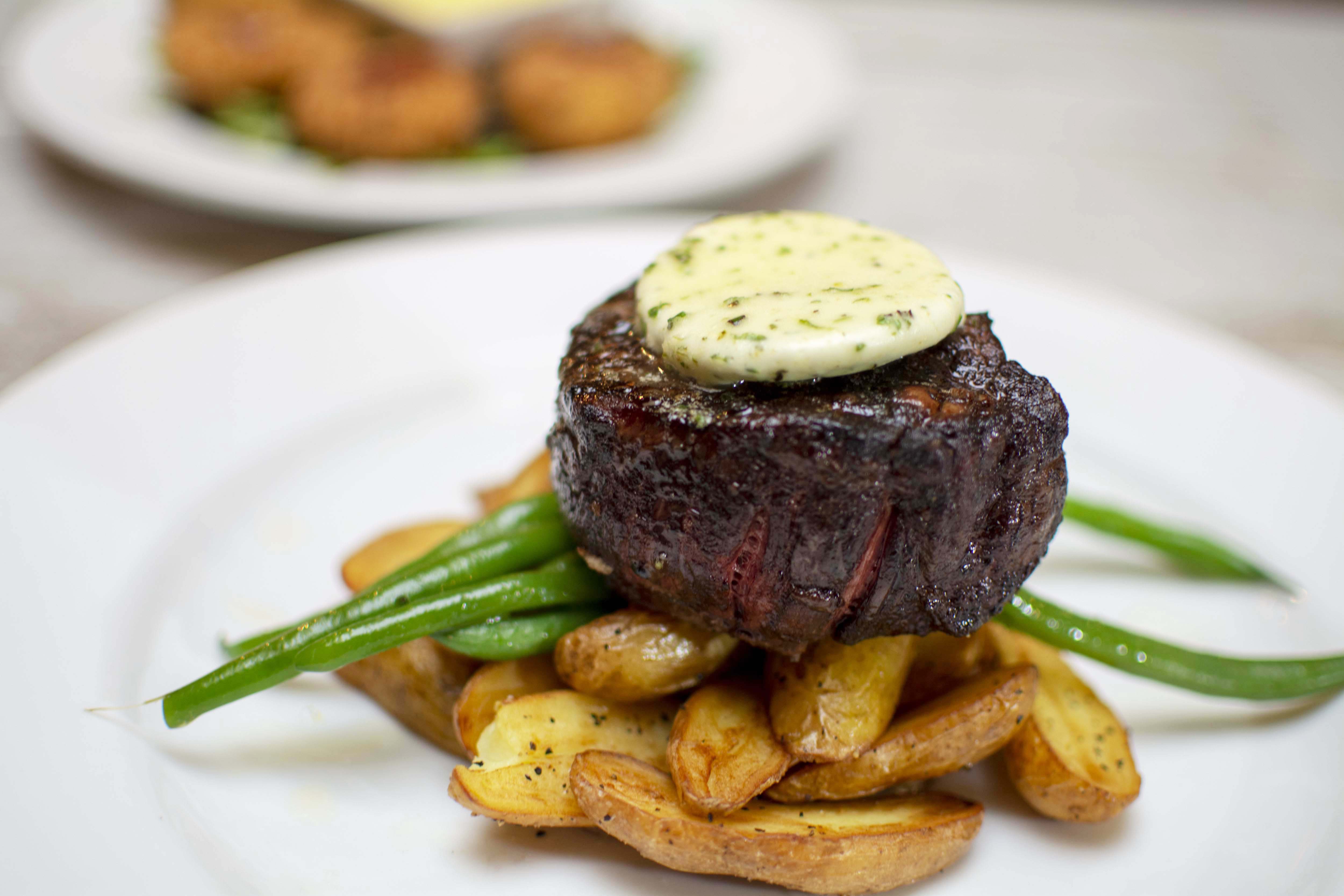 a plate of food with a piece of meat and green beans