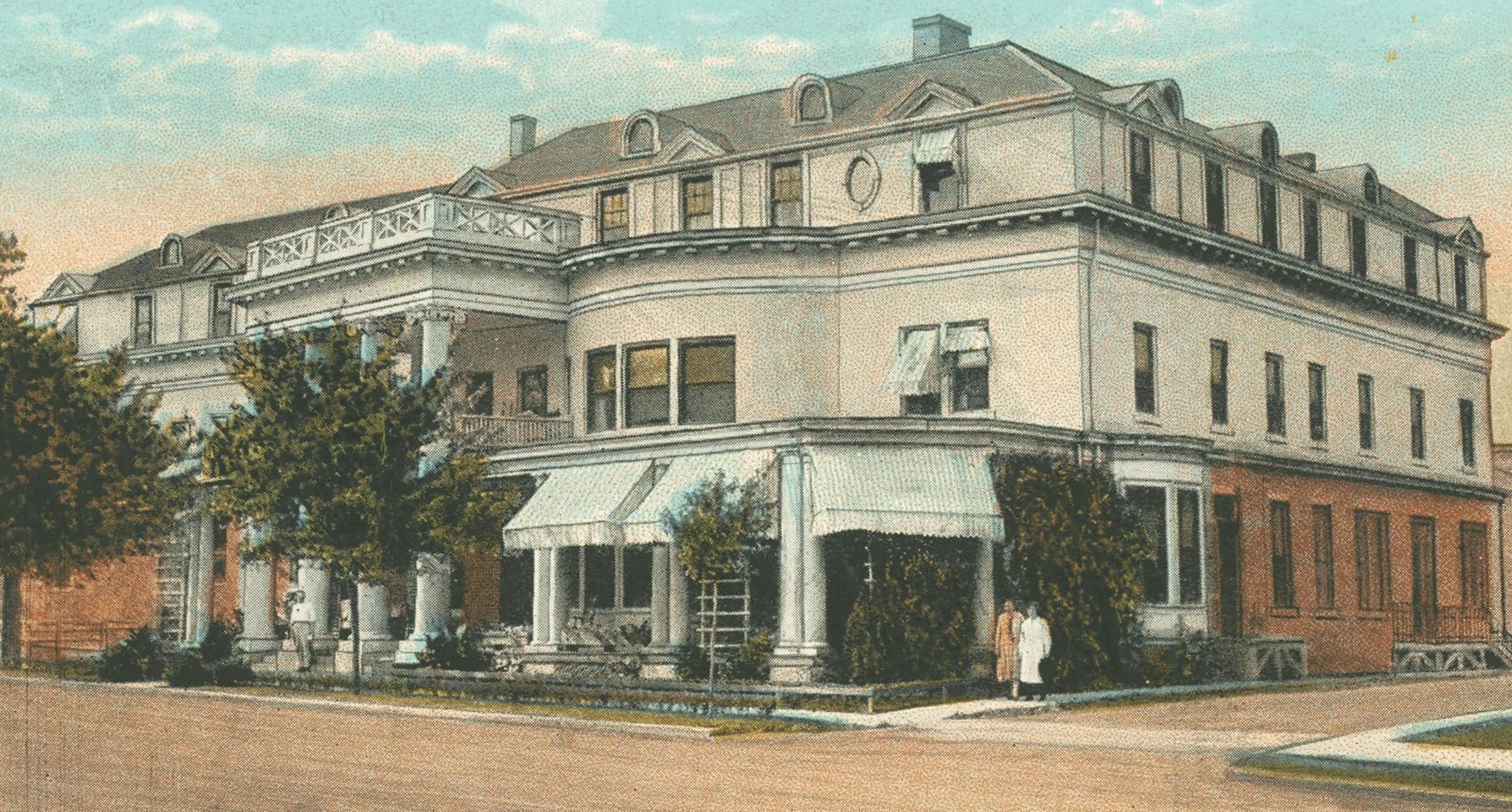 a large white building with a couple of people standing outside