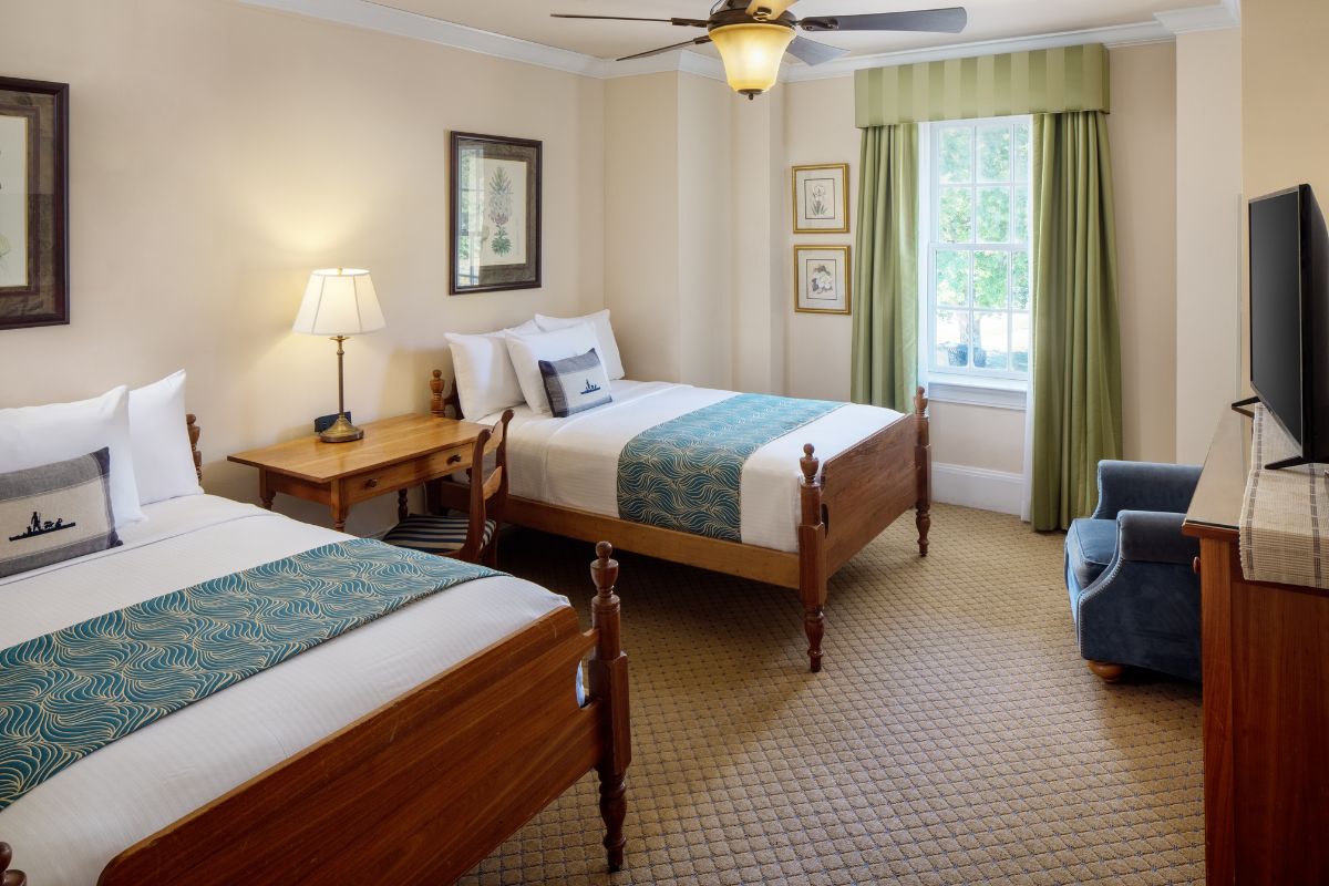 a room with two beds and a fan