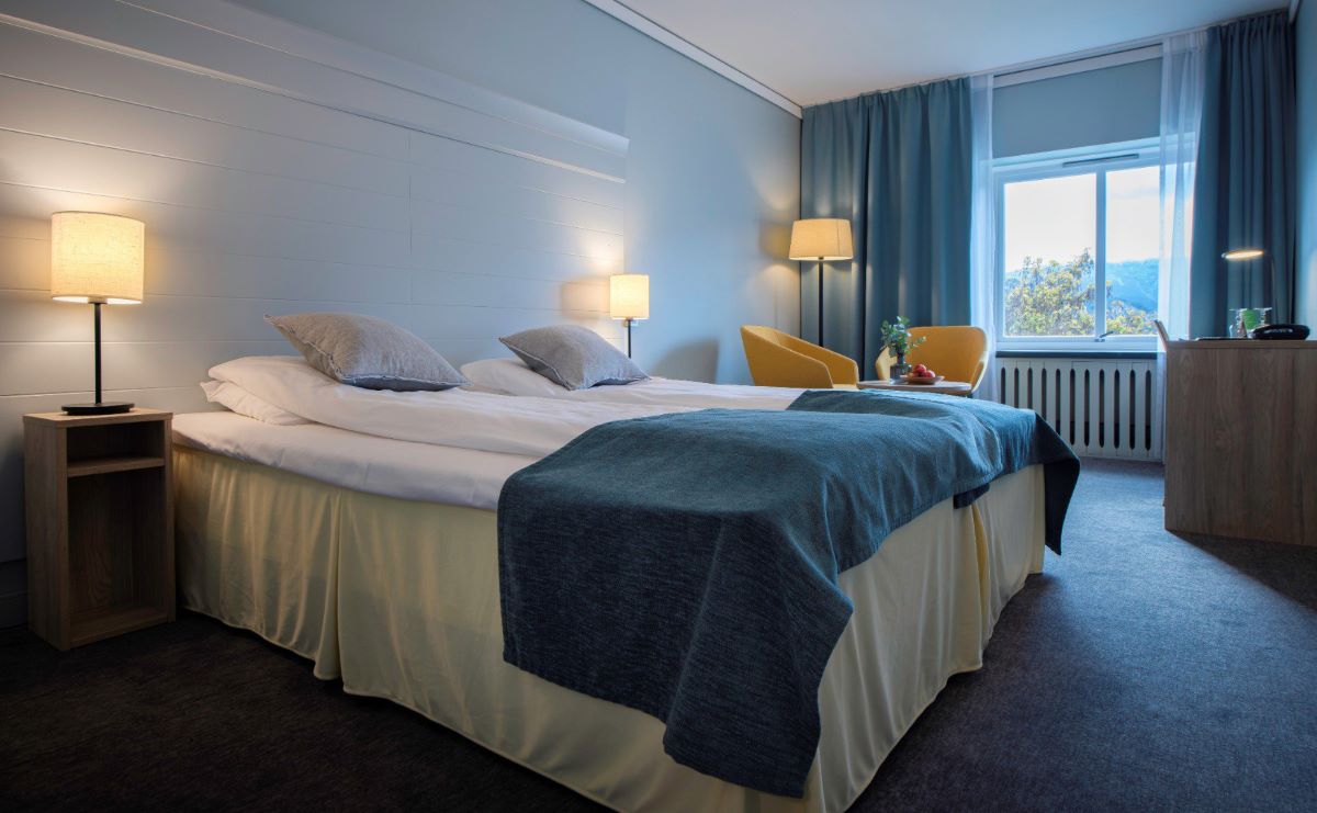 a bed with a lamp and a window
