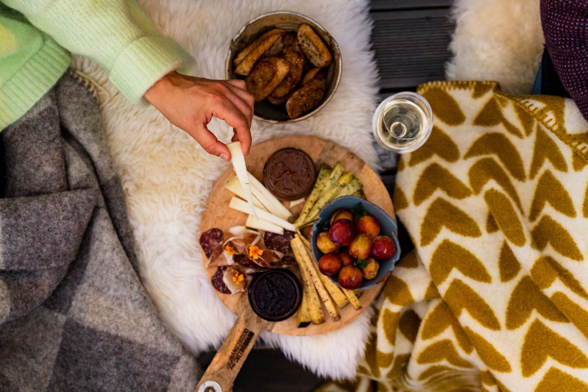 a person holding cheese and a plate of food
