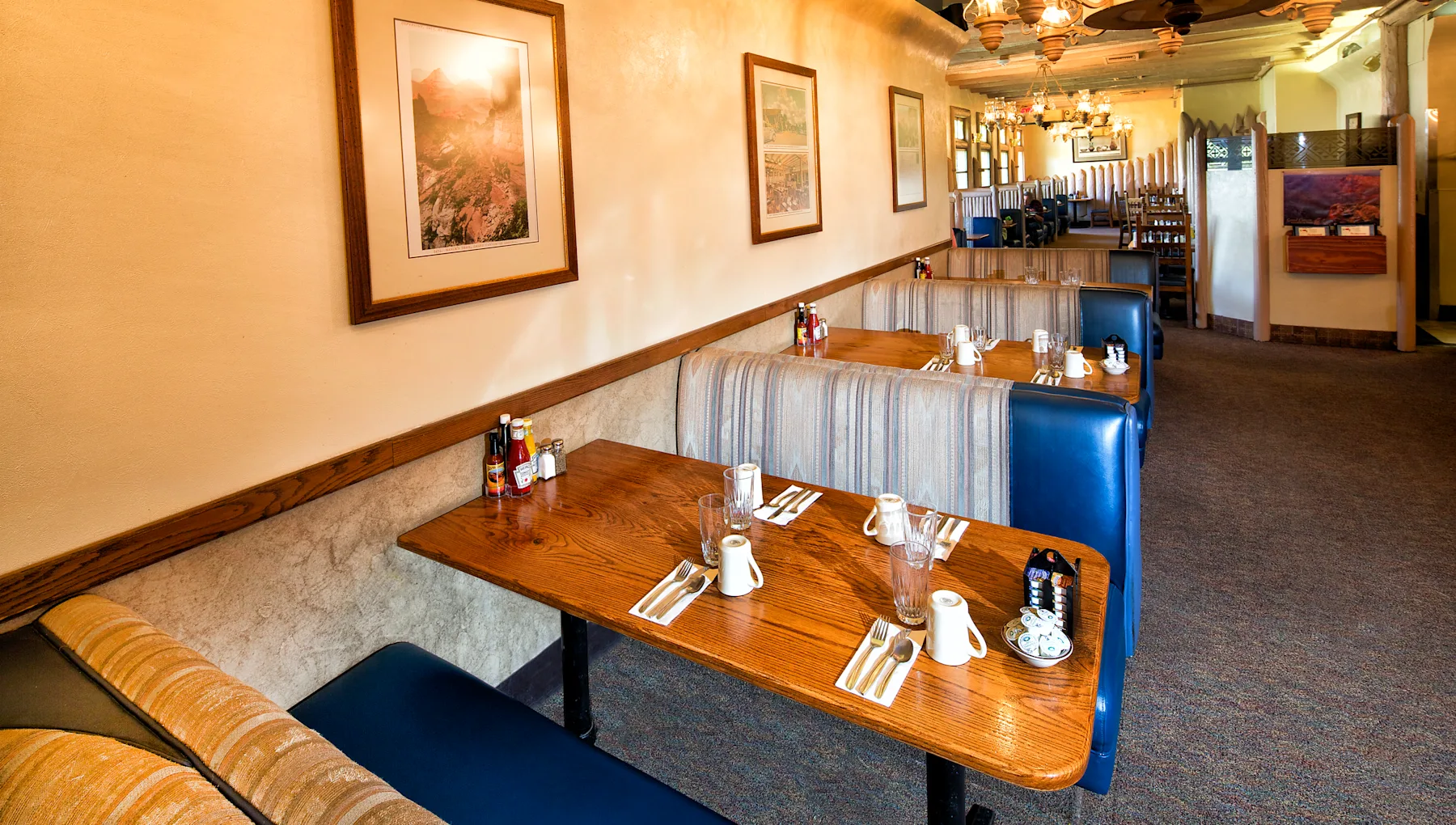 a restaurant with tables and blue booth seats