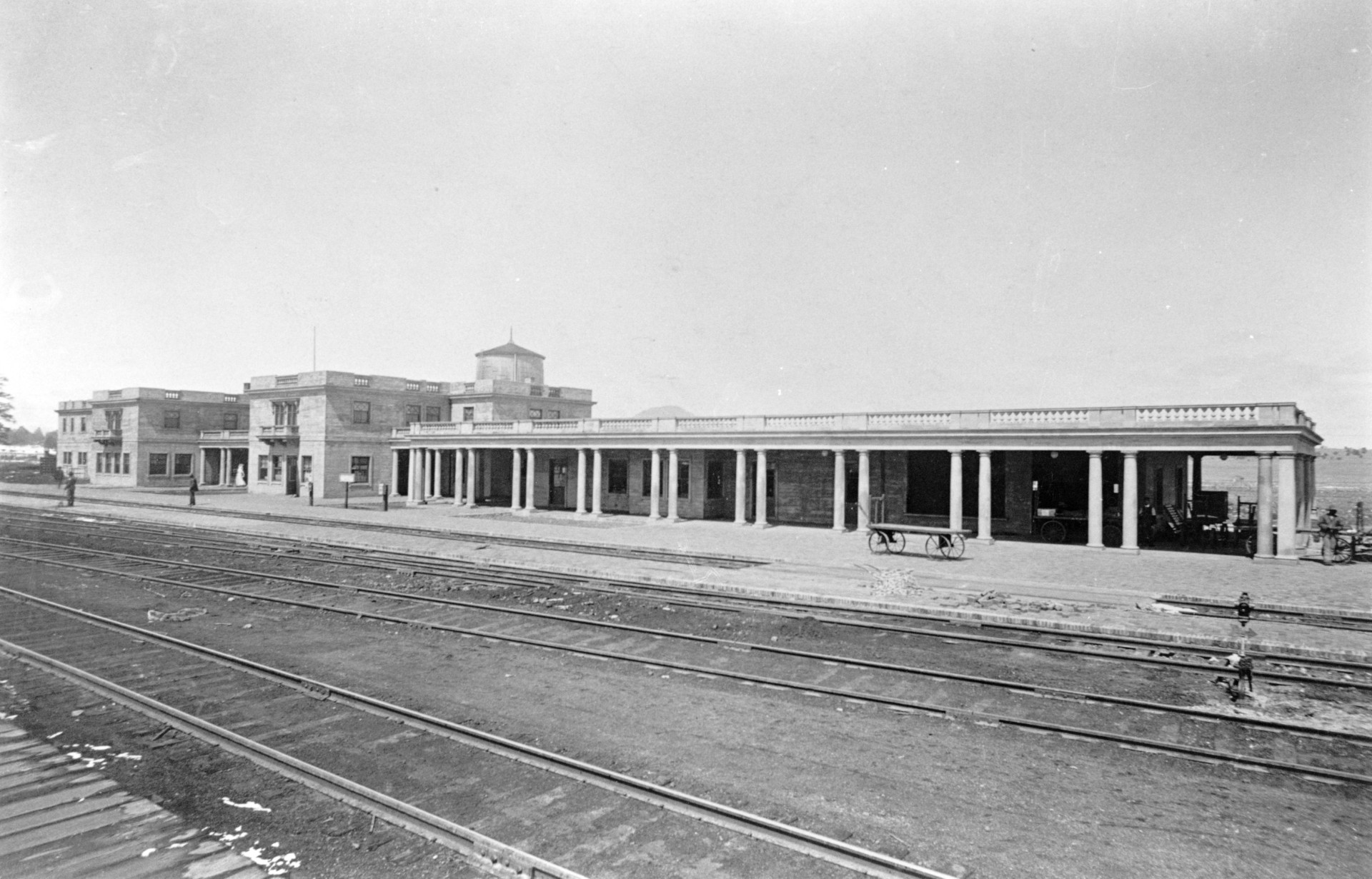 a train station with a carriage and a building