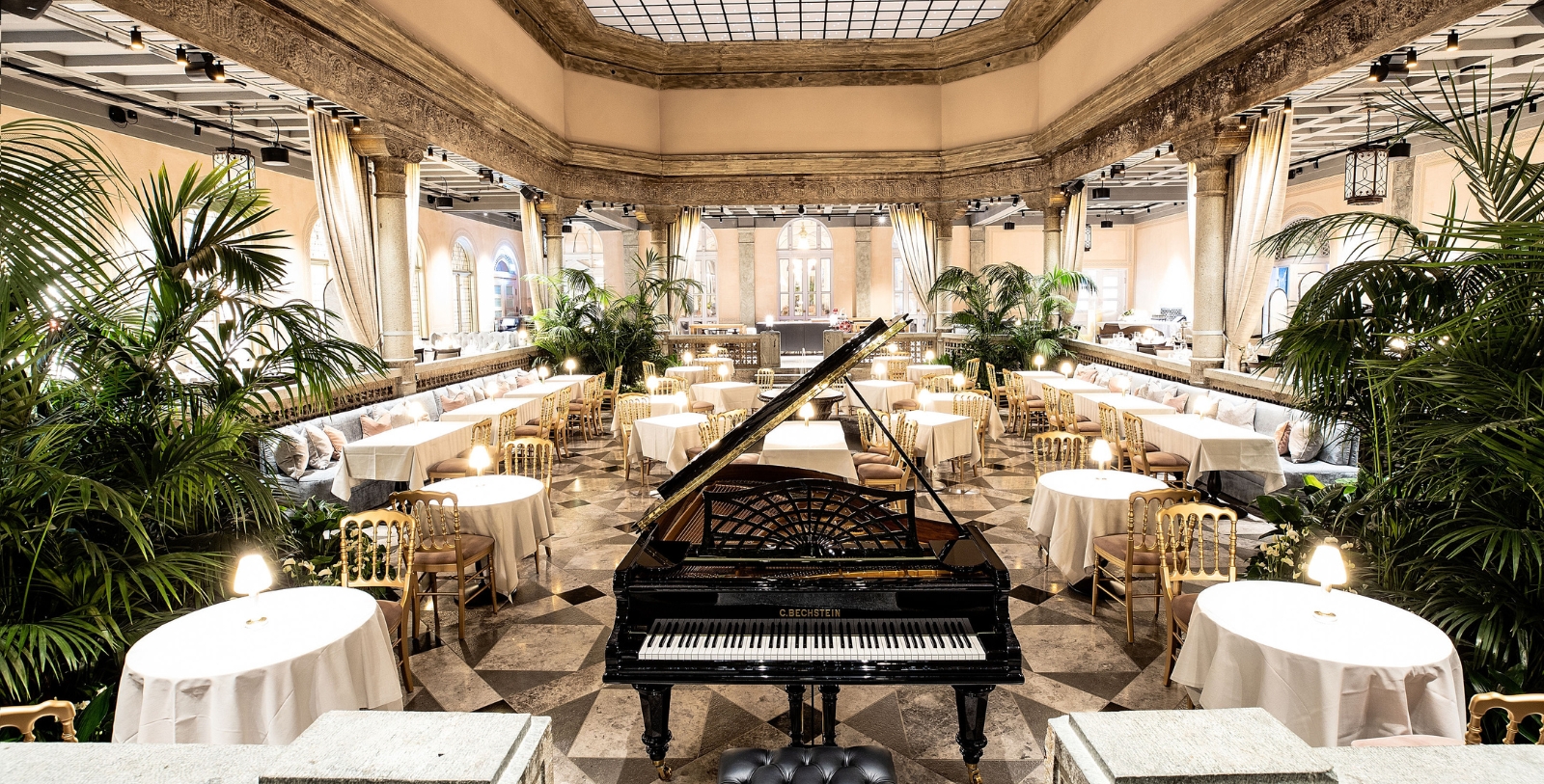 a piano in a room with tables and chairs