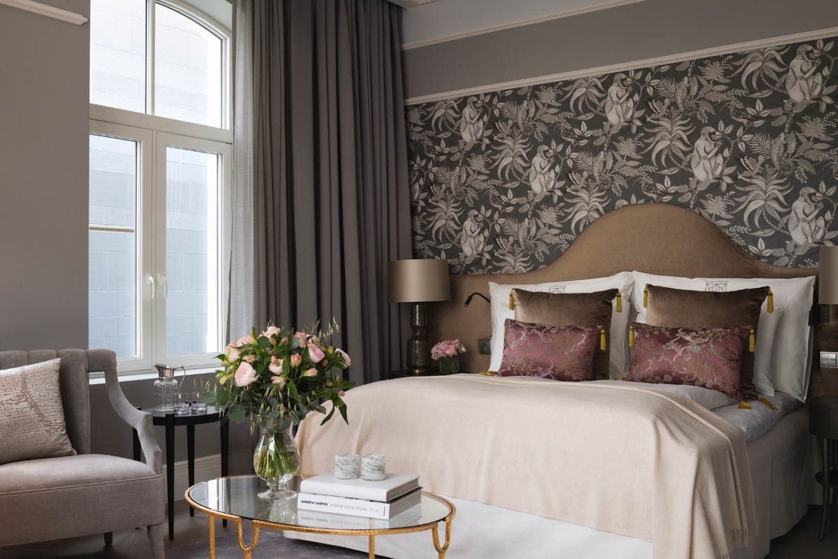 a bedroom with a bed and a vase of flowers