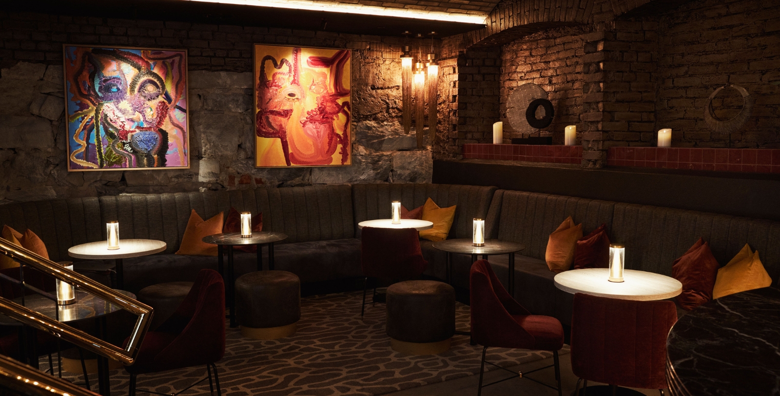 a room with a couch and tables and art