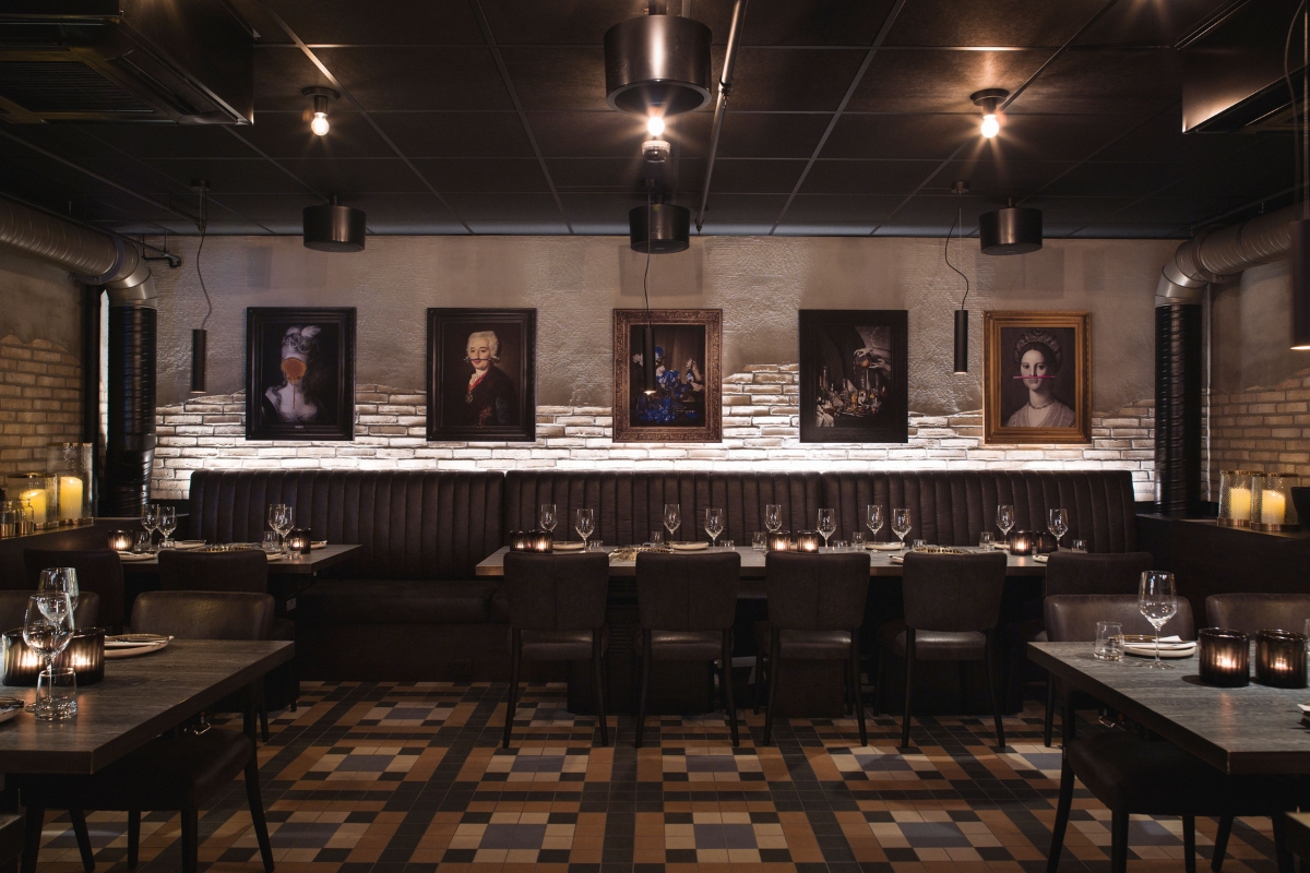 a restaurant with a long booth and a long table with a group of tables and chairs