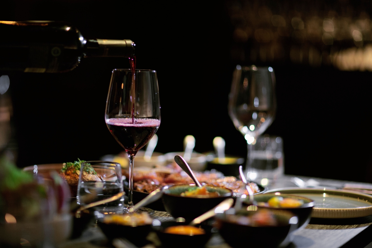 a person pouring wine into a glass