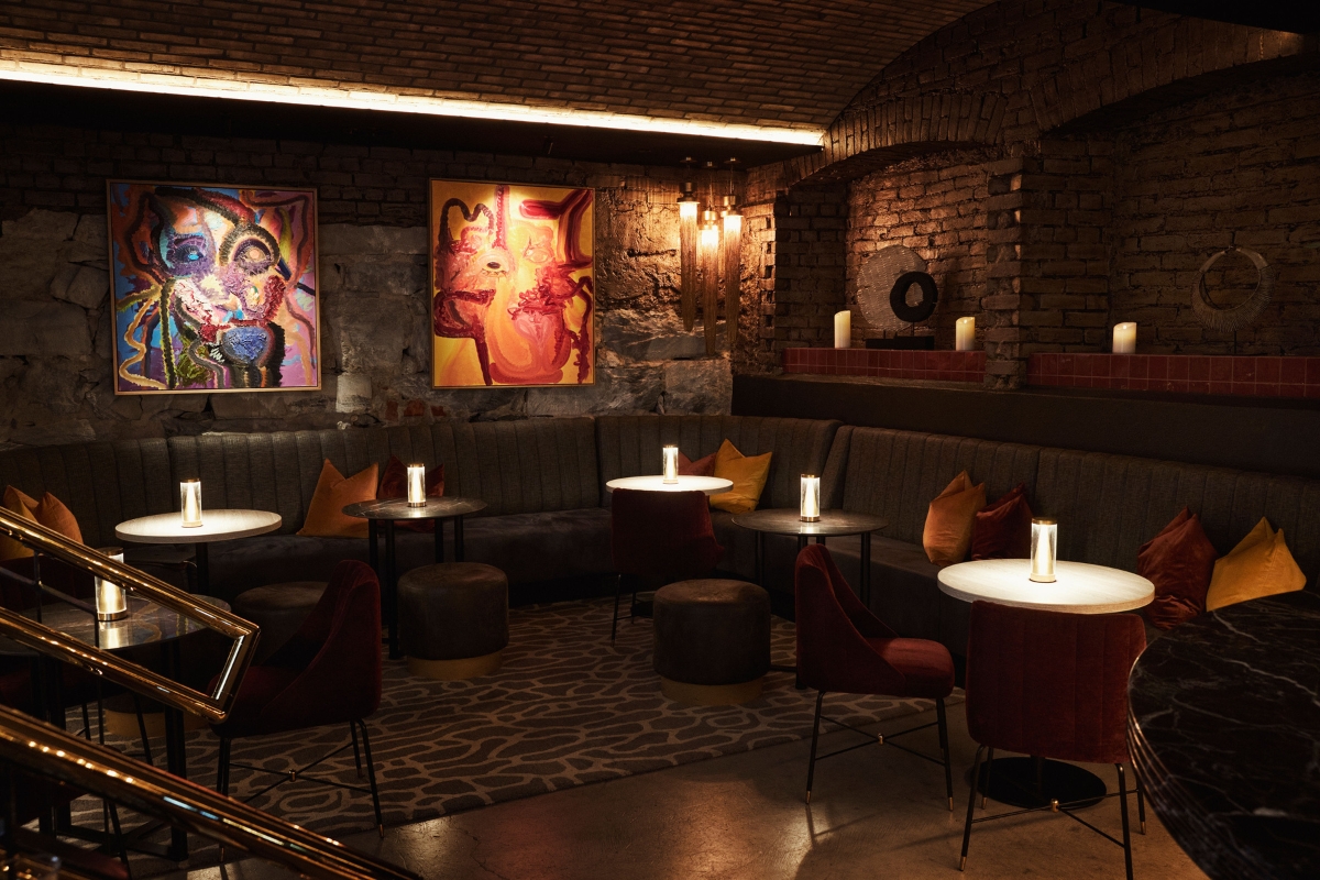 a room with a couch and tables and artwork