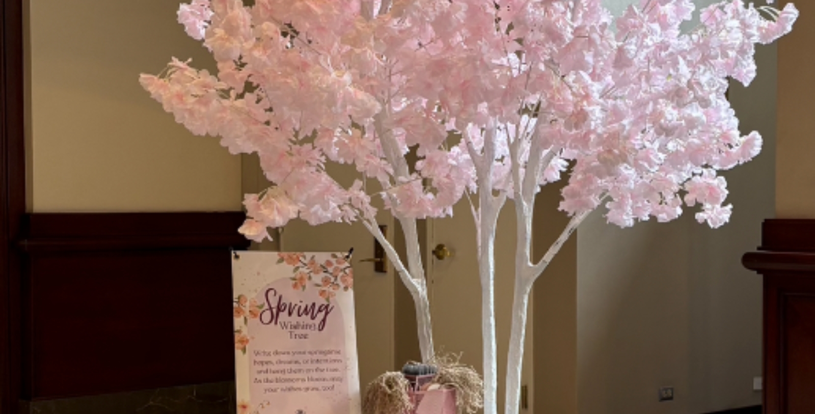 a pink tree with a sign