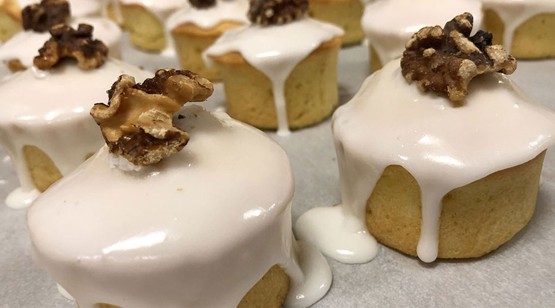 a group of cupcakes with icing and walnuts
