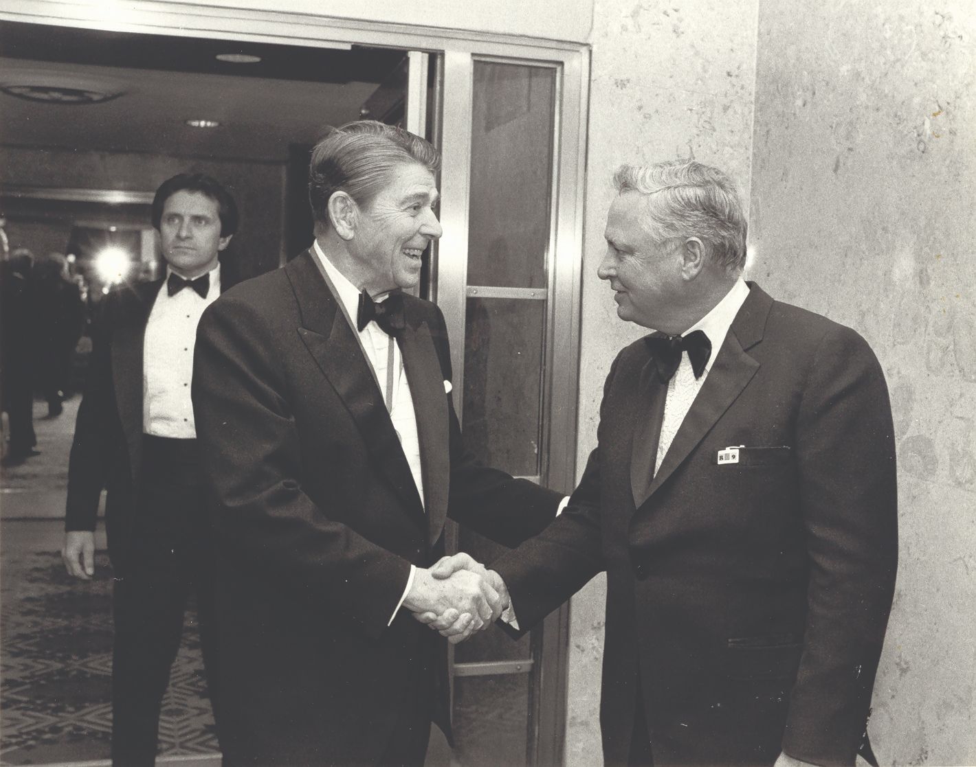 a man in a suit shaking hands with another man in a suit