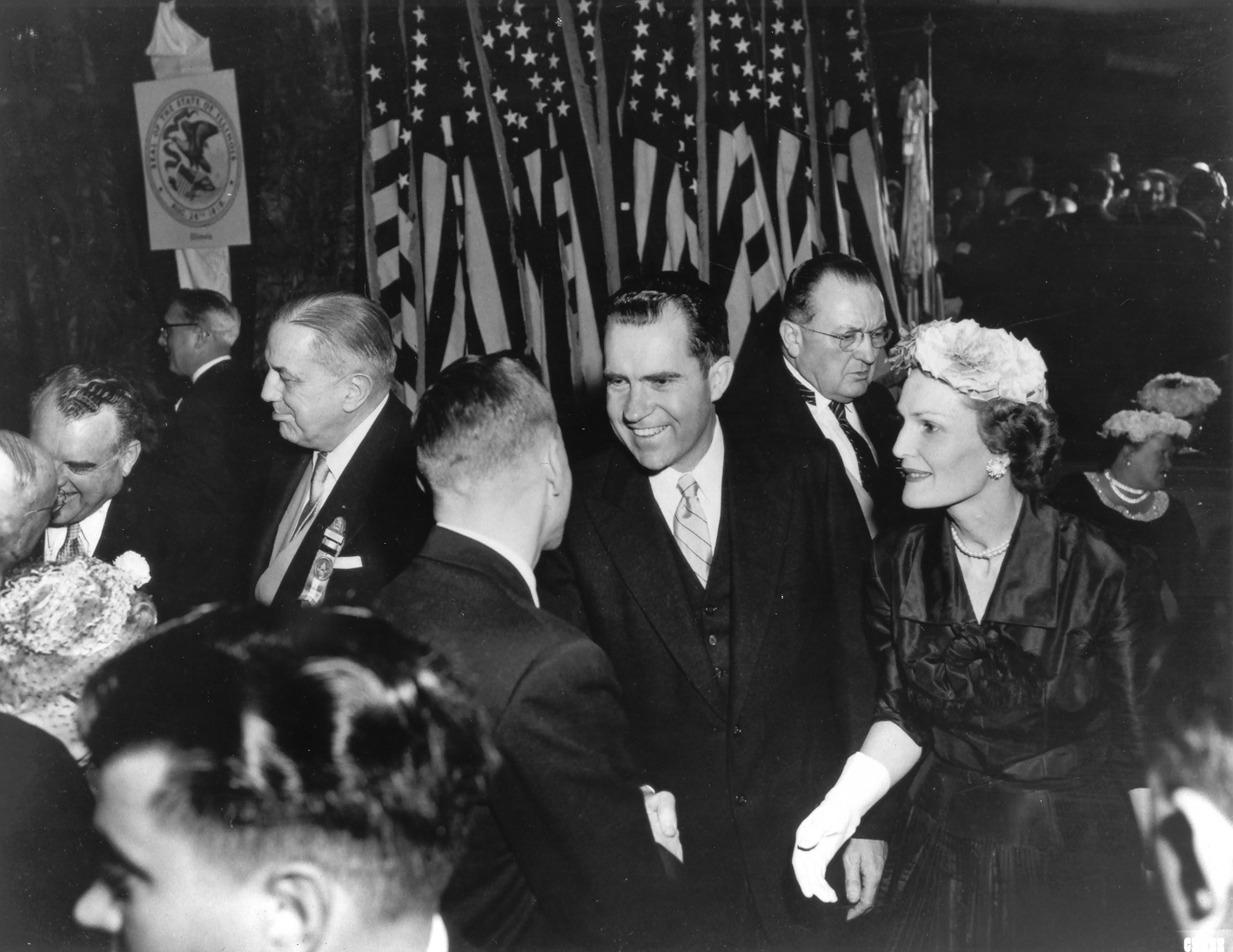 a group of people in a room with flags