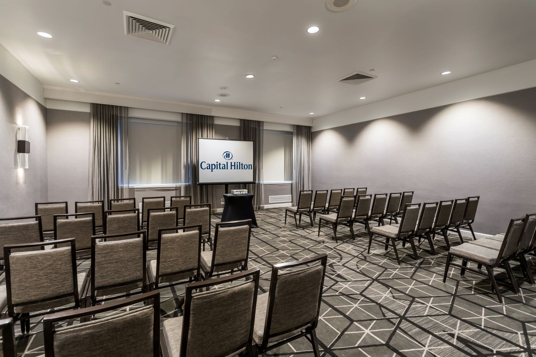 a room with chairs and a screen