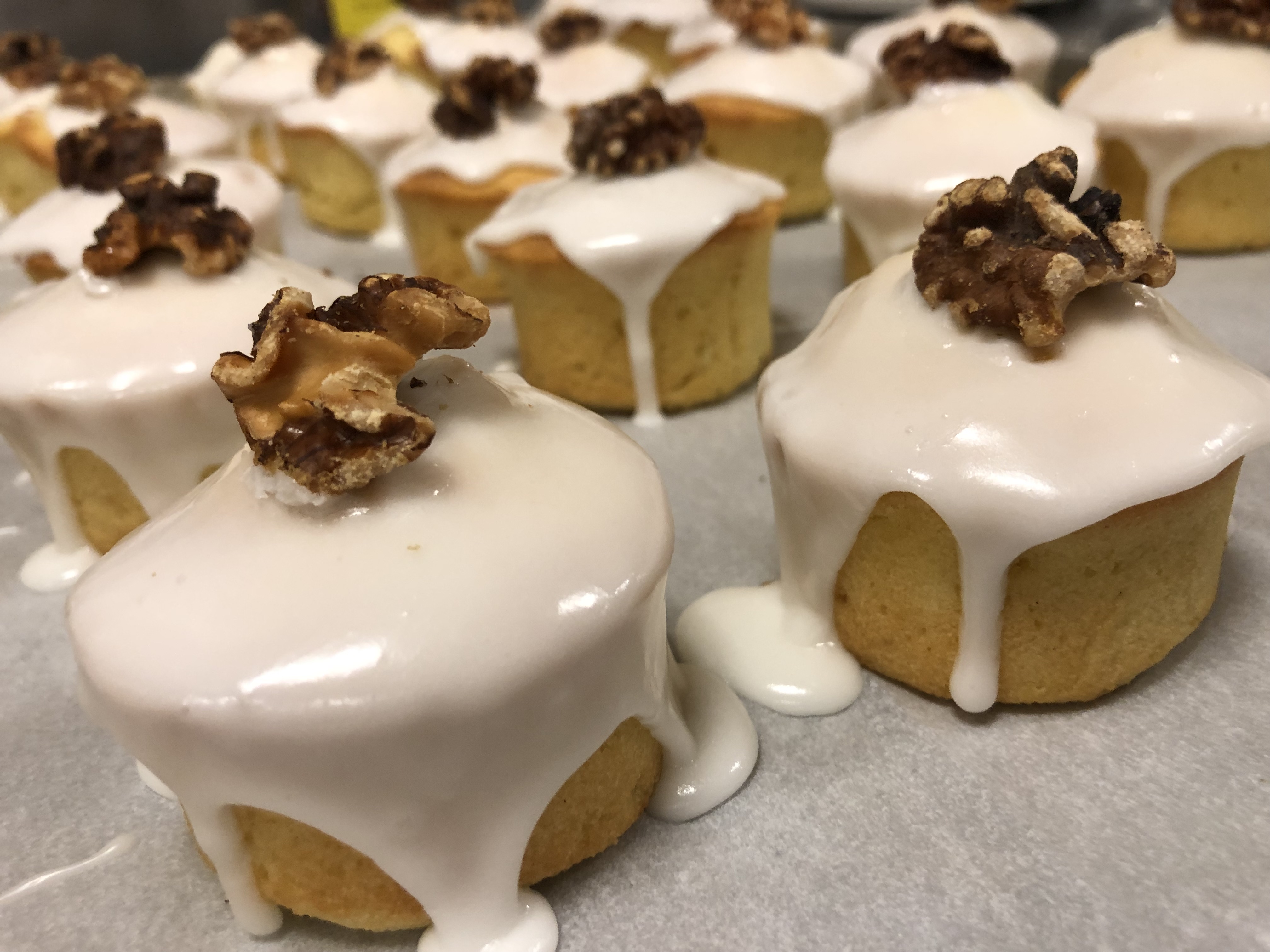 a group of cupcakes with white frosting and walnuts