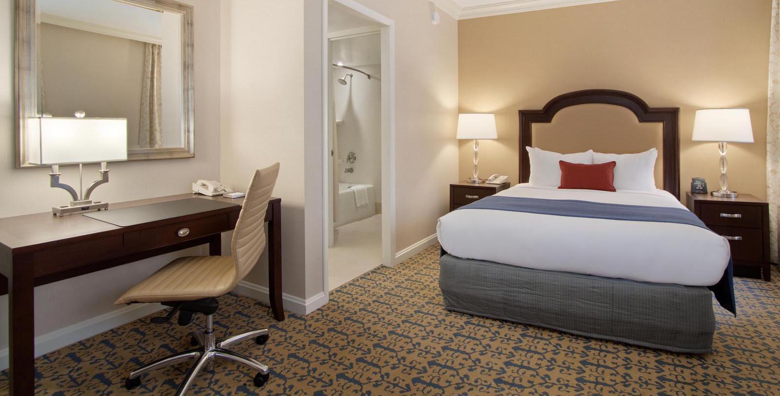a hotel room with a bed and desk