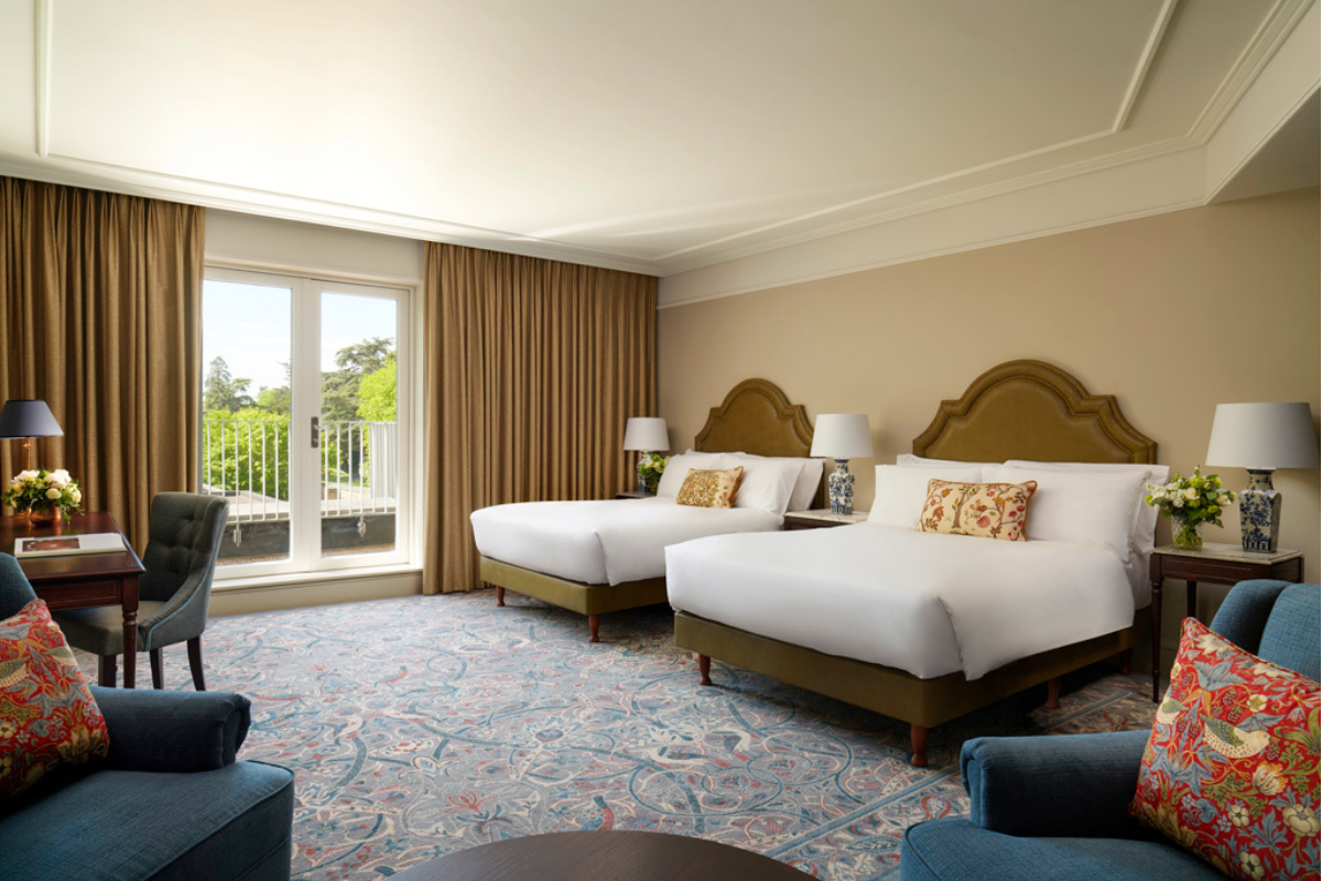 a room with two beds and a door to a balcony