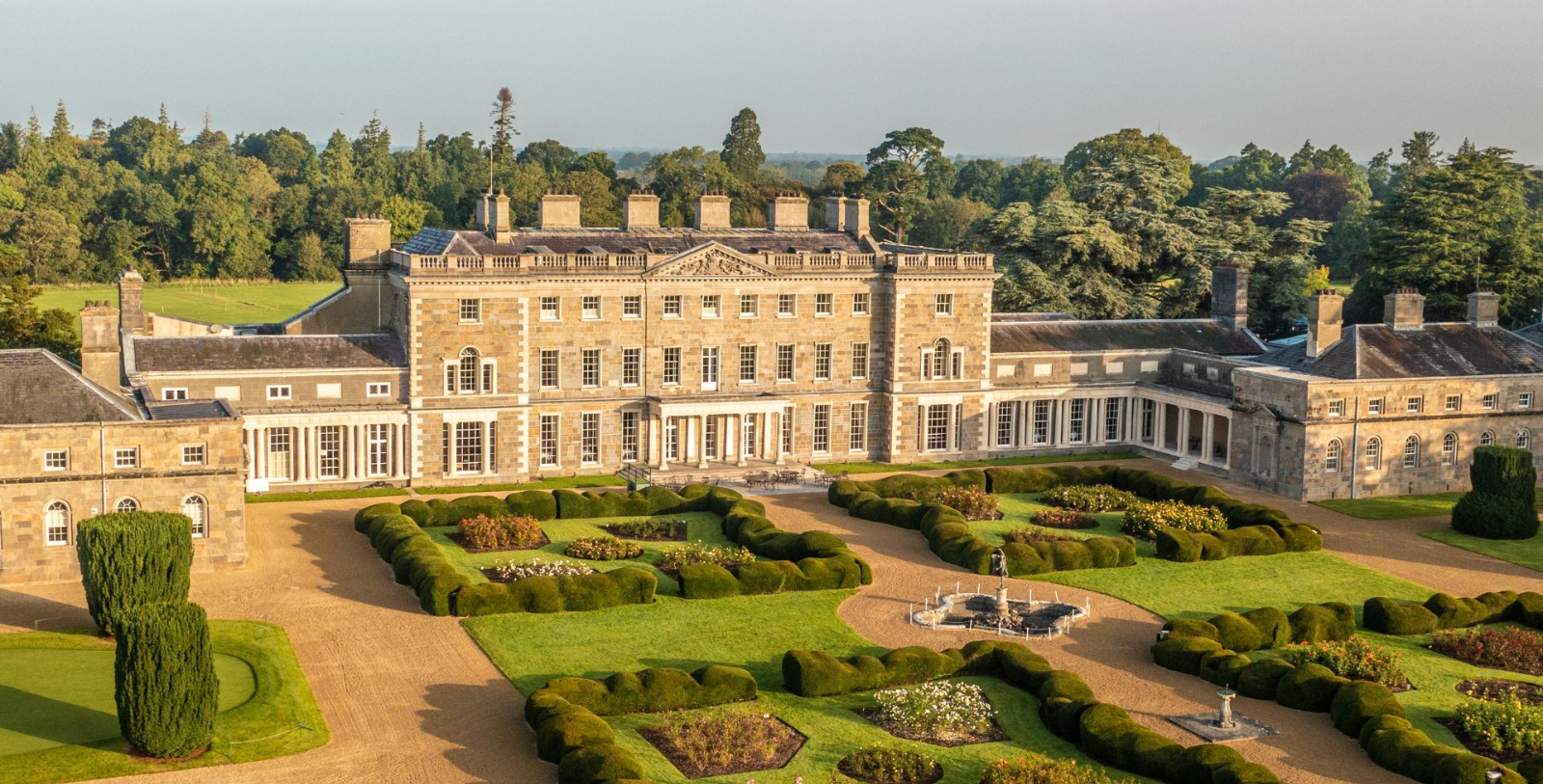 a large stone building with a fountain and a garden
