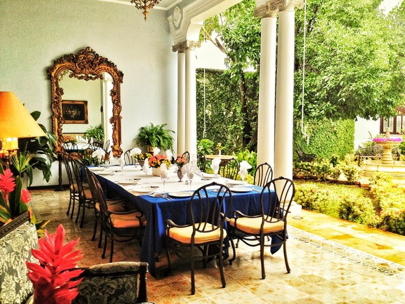 a dining table with chairs and a mirror