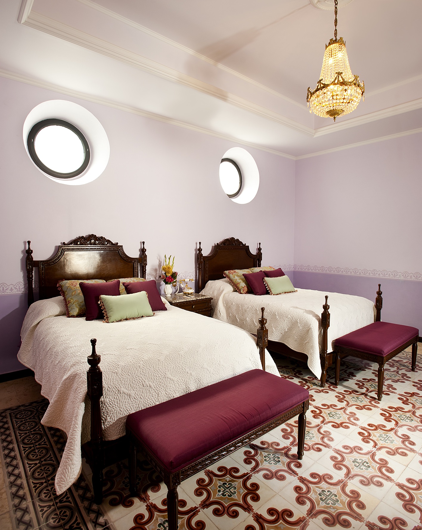 a bedroom with two beds and a chandelier