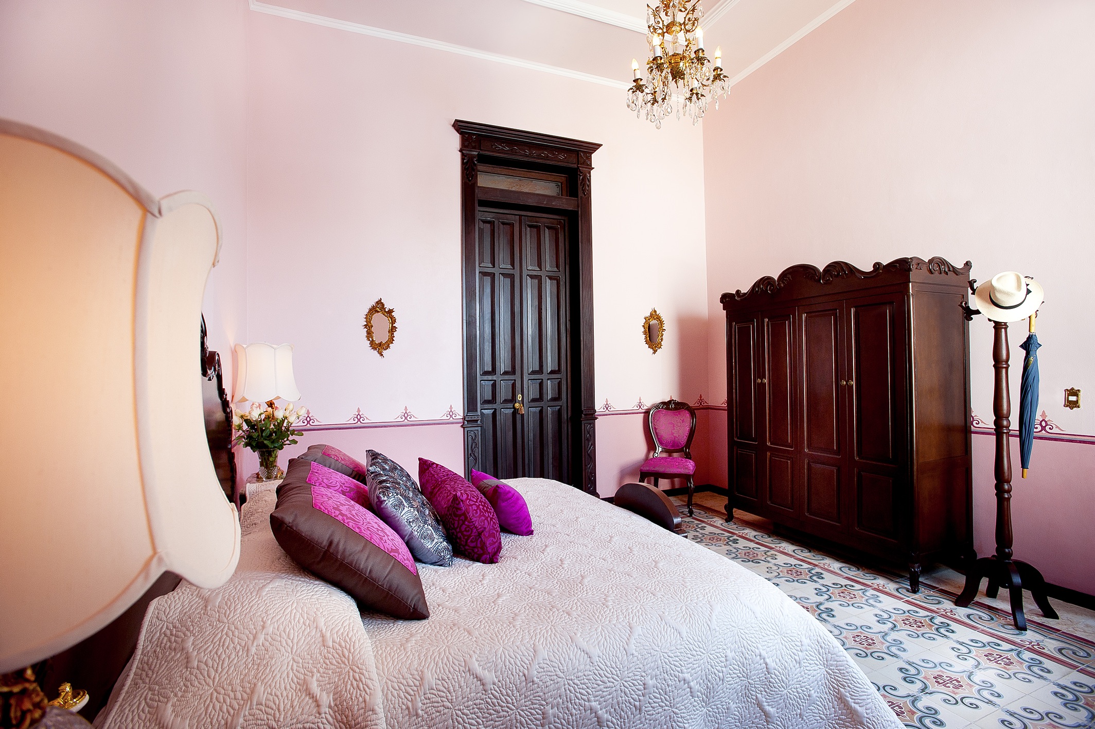 a bedroom with a bed and a chandelier